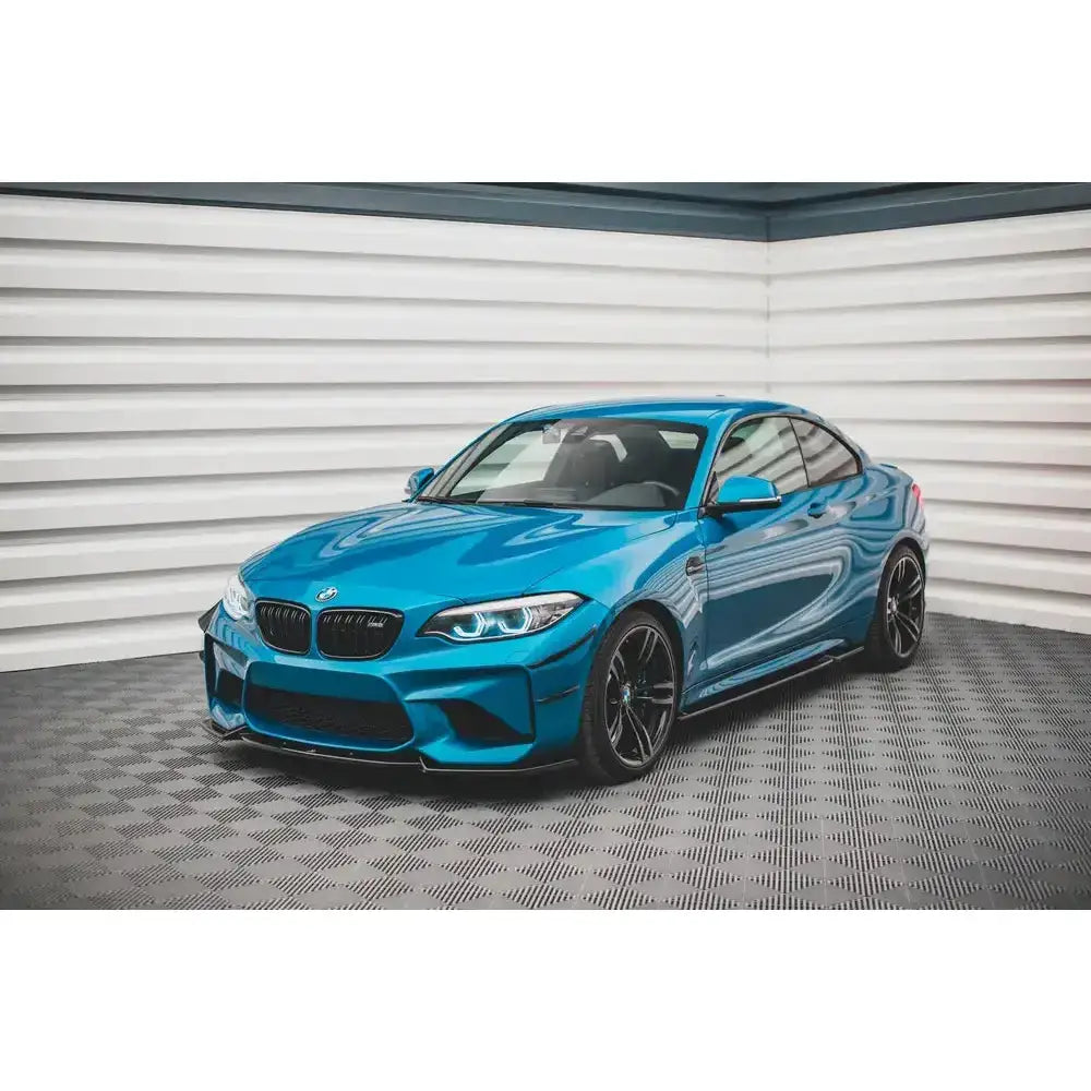 Frontspoiler på blå BMW M2 F87 V.2 avbildet fra venstre front med svarte felger og markante frontlykter.