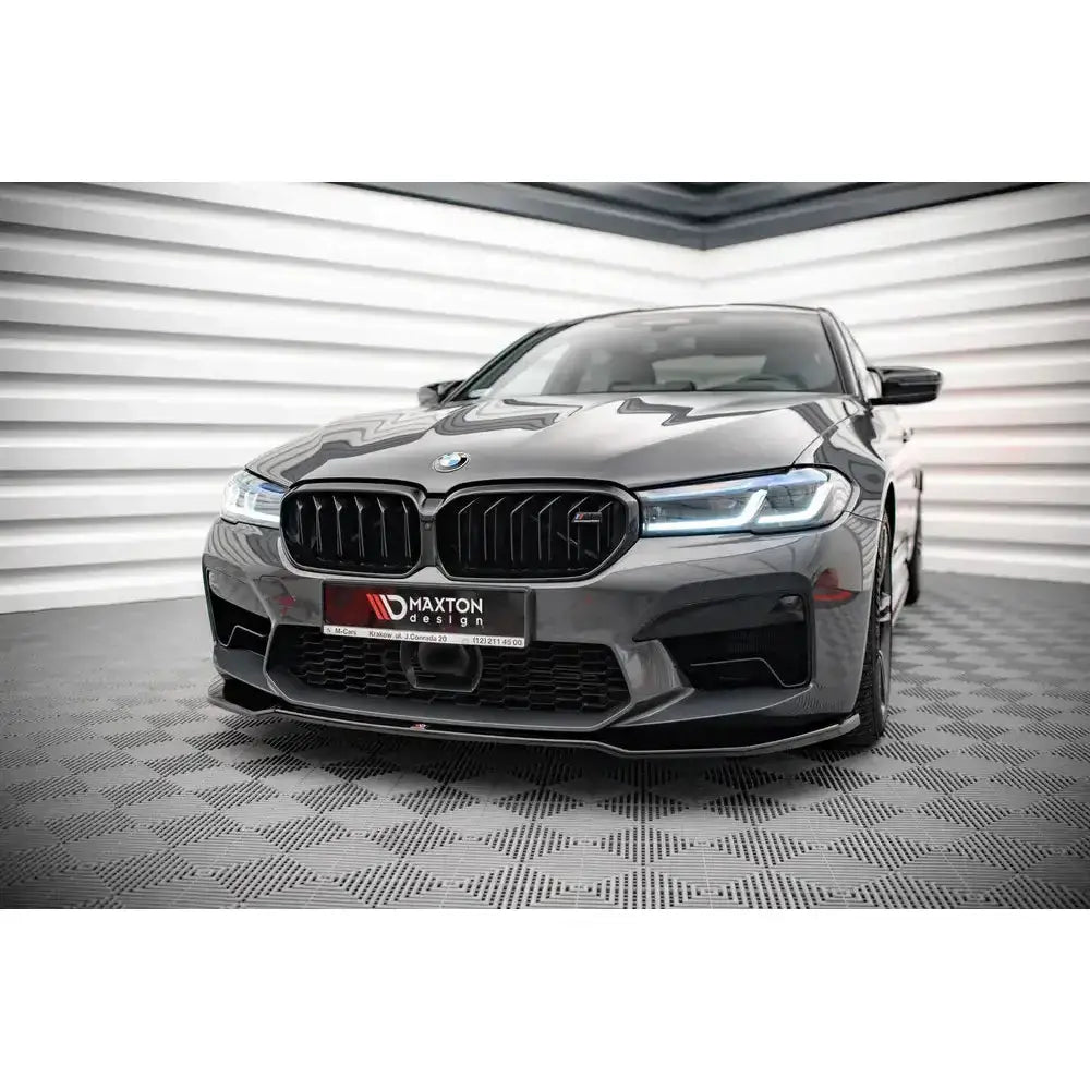 Frontsplitter på BMW M5 F90 Facelift med sorte detaljer og LED-frontlykter i lyst rom.