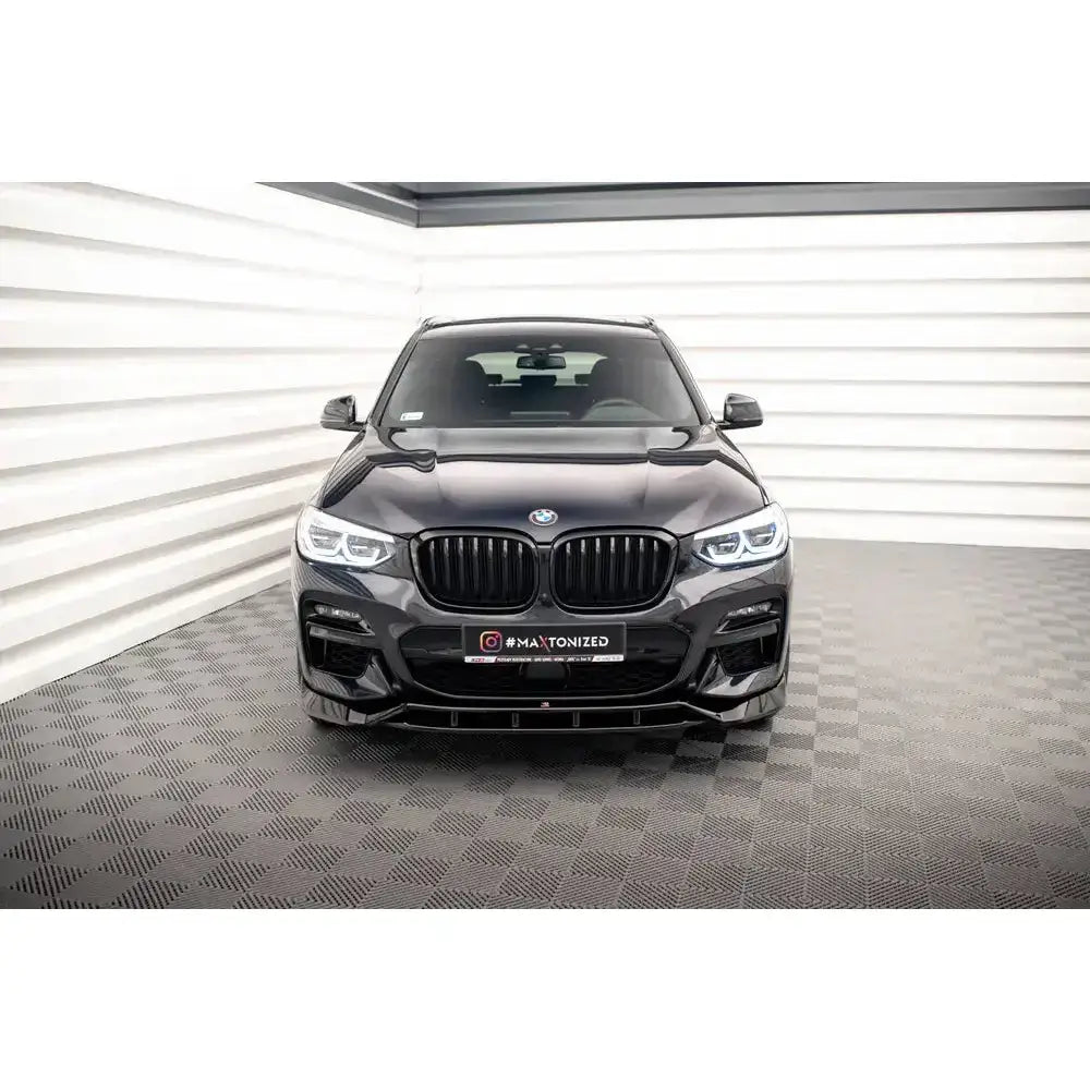 Frontspoiler på BMW X3 M40d med blanke sorte detaljer og markerte frontlykter sett rett forfra.