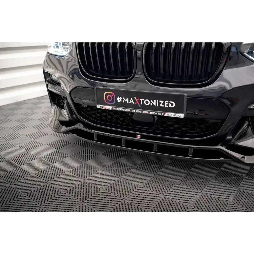 Frontsplitter på BMW X3 M40d G01 med blank svart finish, detaljerte luftinntak og refleks.