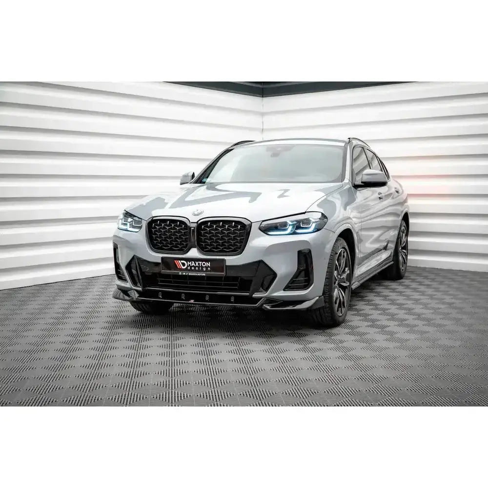 Frontspoiler til BMW X4 M-Pack G02 Facelift, vist på sølvfarget bil med svarte grilldetaljer.