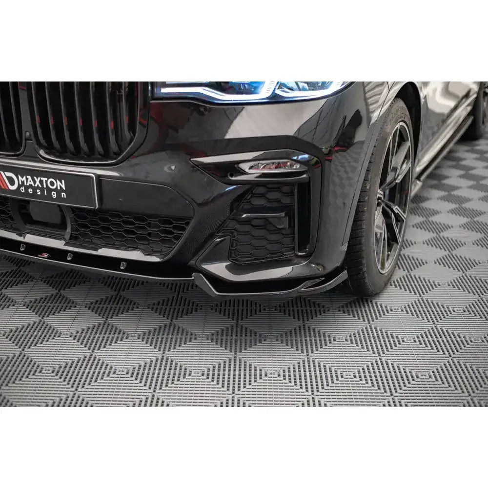 Frontsplitter på BMW X7 M G07 med blanke detaljer, store felger og markert grill, sett skrått forfra.