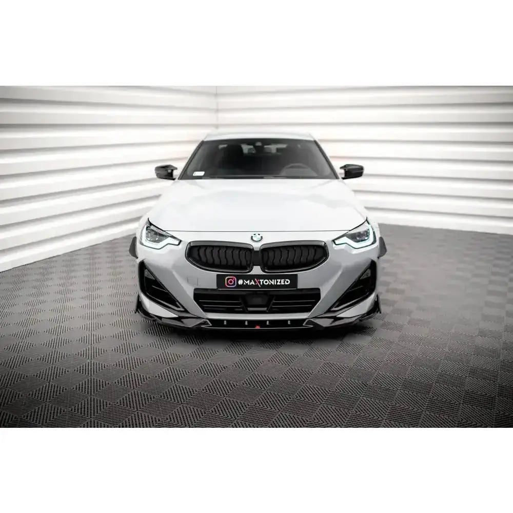 Frontspoiler på hvit BMW 2 Serie Coupe M-Pack G42 med sorte detaljer foran lyst veggpanel.