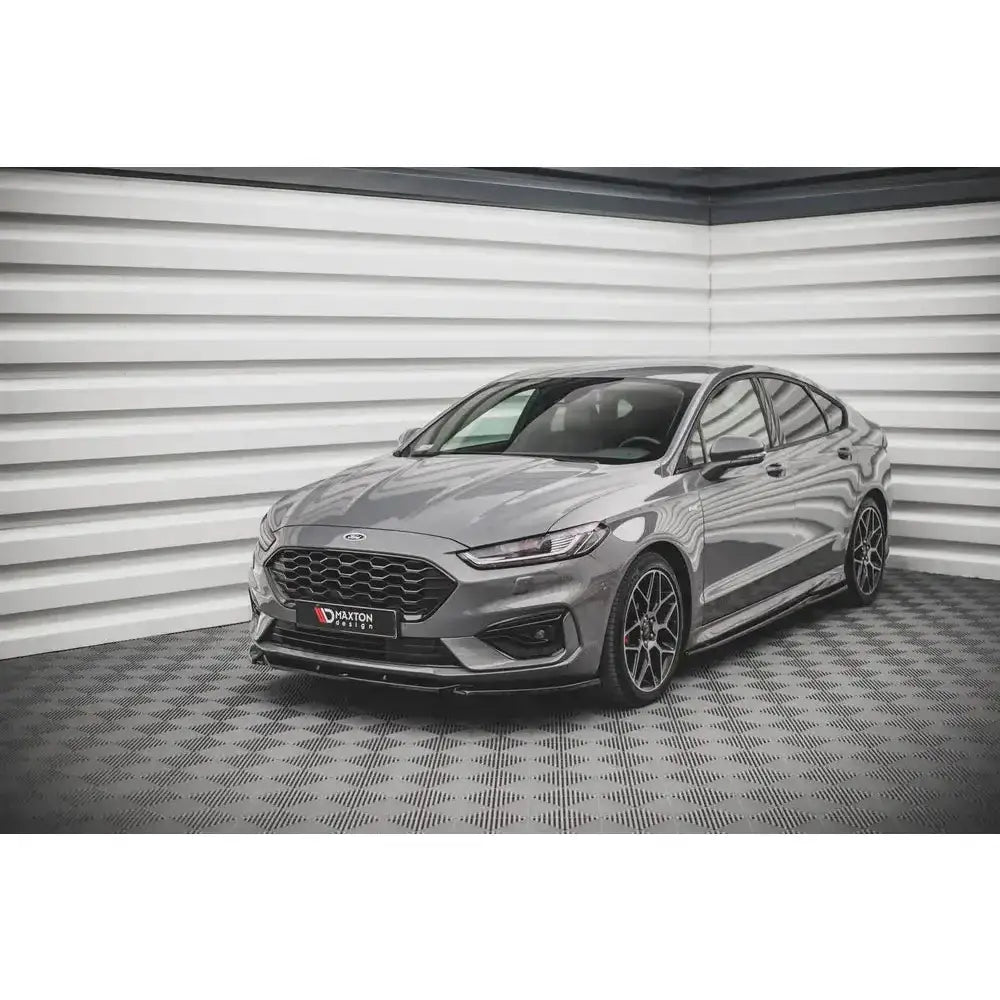Frontsplitter på Ford Mondeo ST-Line Mk5 Facelift med mørke felger i lyst rom med mønstret gulv.
