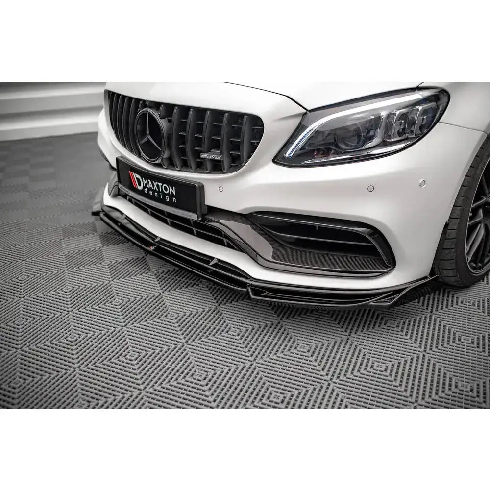 Frontsplitter til Mercedes AMG C63 Coupe C205 Facelift, sort glanset finish sett forfra på mønstret gulv.