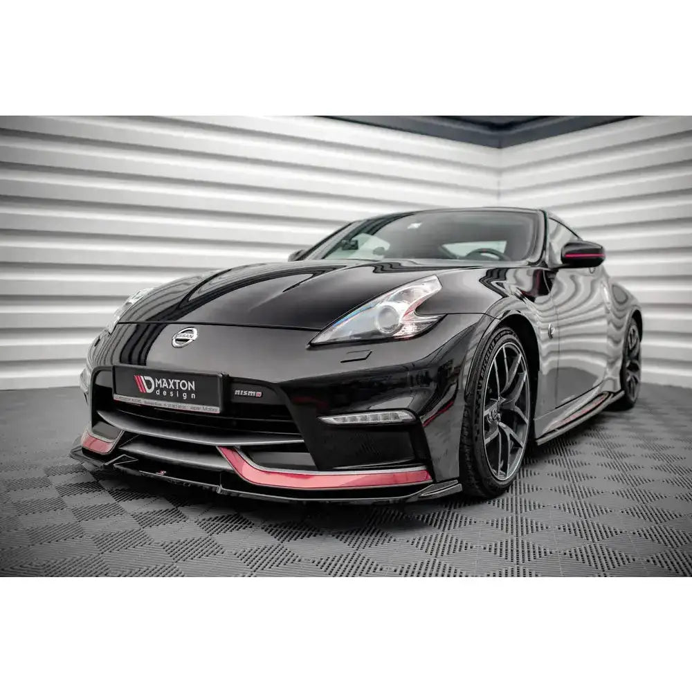 Front lip på Nissan 370Z Nismo Facelift med røde detaljer, sett skrått forfra på rutemønstret gulv.