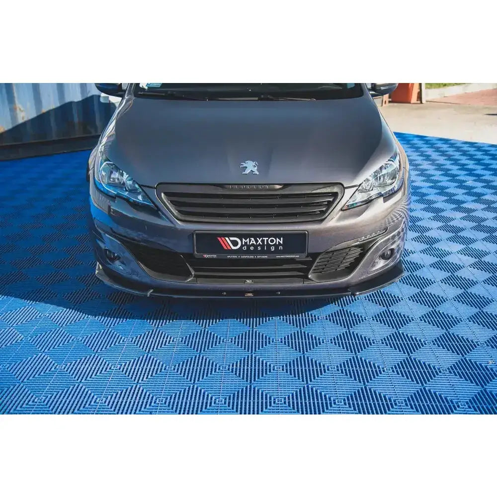 Frontspoiler på Peugeot 308 Mk2 Facelift V.2, svart spoiler montert på grå bil, sett forfra.