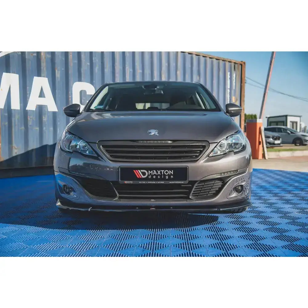 Frontsplitter til Peugeot 308 Mk2 Facelift, sort med Maxton Design-logo, montert på grå bil.
