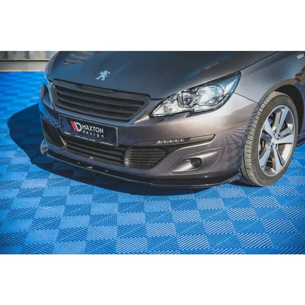 Front splitter på Peugeot 308 Mk2 Facelift med svart leppe, aluminiumsfelger og blått rutete gulv.