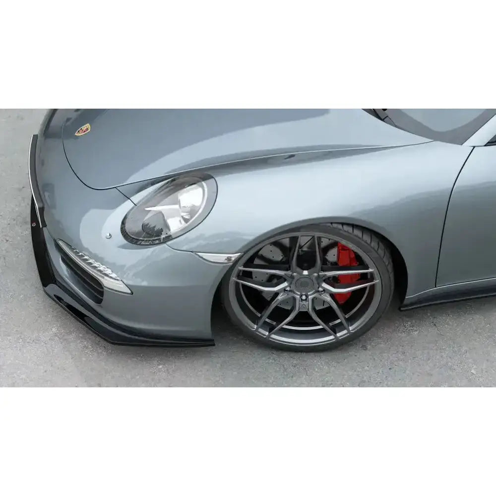 Frontsplitter på Porsche 911 Carrera 991 sett fra siden med mørk grå felg og røde bremsecalipere.