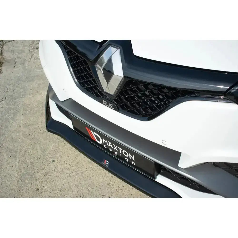 Front splitter på Renault Megane IV Rs med sort grill, R.S.-emblem og hvit støtfanger på asfalt.
