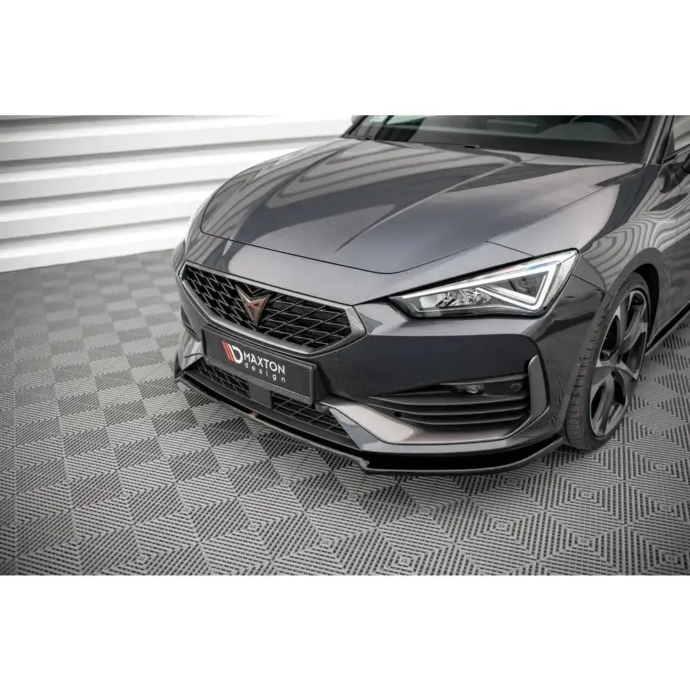Frontsplitter på mørk grå Seat Cupra Leon med sportslig design og svart grill, sett fra skrå vinkel.