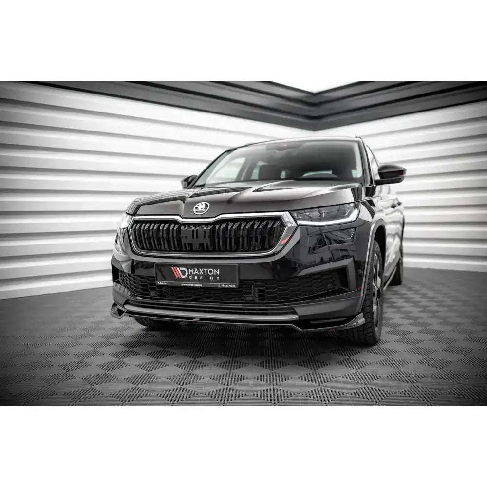 Frontsplitter på Skoda Kodiaq Mk1 Facelift SUV sett forfra med blank svart grill på rutemønstret gulv.