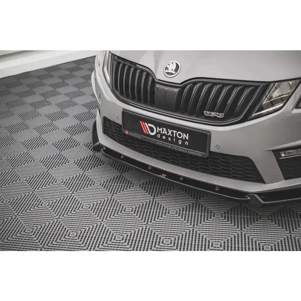 Frontsplitter på Skoda Octavia RS Mk3 Facelift V.2, sort plast, vises skrått forfra mot grått gulv.