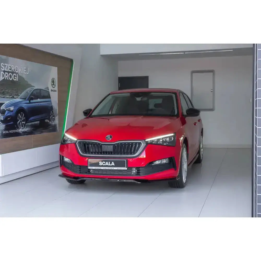 Frontsplitter på rød Skoda Scala V.2 med LED-frontlykter og sort grill, fotografert rett forfra.