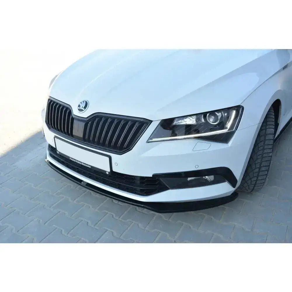Front splitter på Skoda Superb III med hvit lakk, sort grill og svart frontspoiler under støtfangeren.