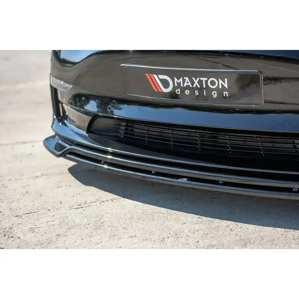 Front lip på sort Tesla Model 3 med blank plastspoiler fra Maxton Design, sett fra skrå vinkel.