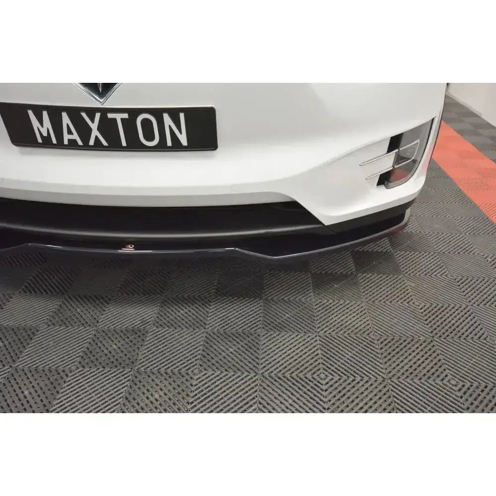 Frontsplitter på hvit Tesla Model X montert under støtfanger, vist på mønstret gulv.