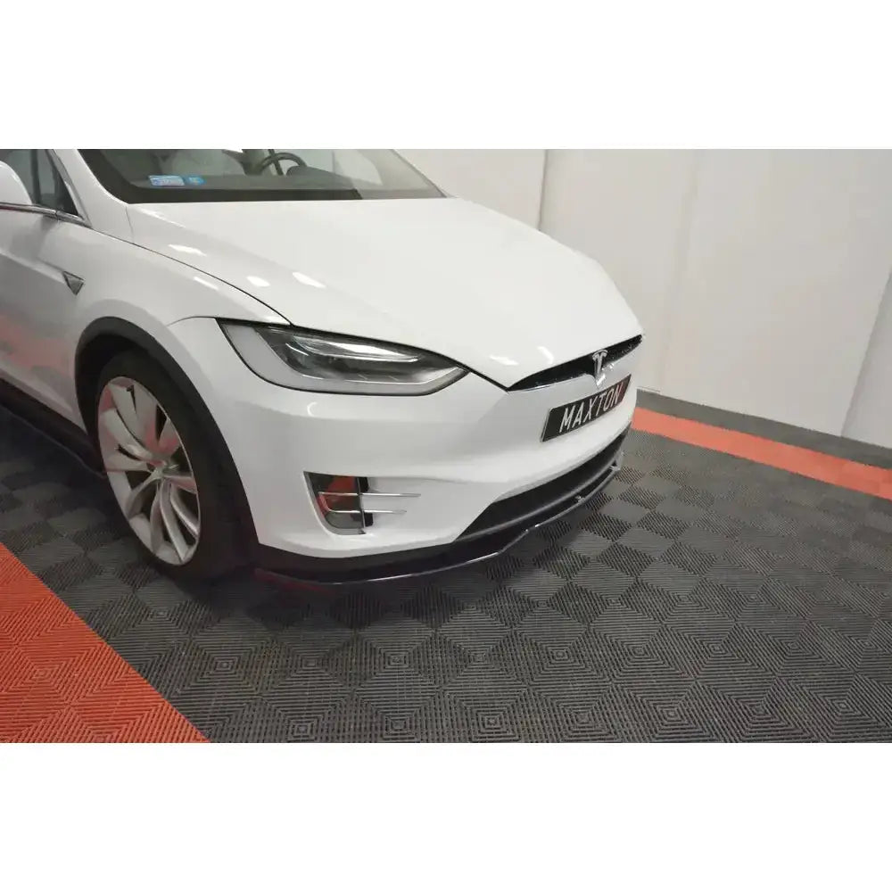 Front lip på Tesla Model X V.2, hvit bil med karbonfiberfrontleppe sett fra siden og forfra.