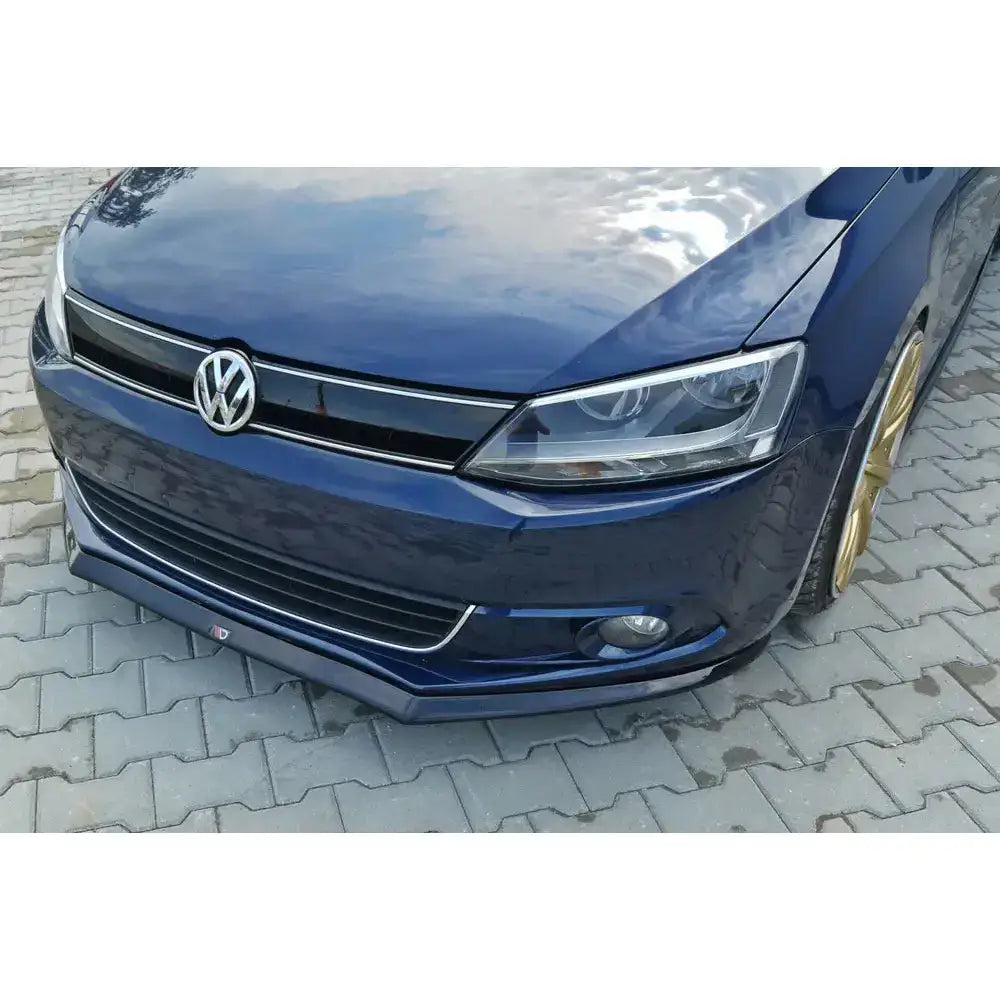 Frontleppe V.2 Volkswagen Jetta Mk6 sedan med gullfelger og tydelig grill, sett fra skrå vinkel.