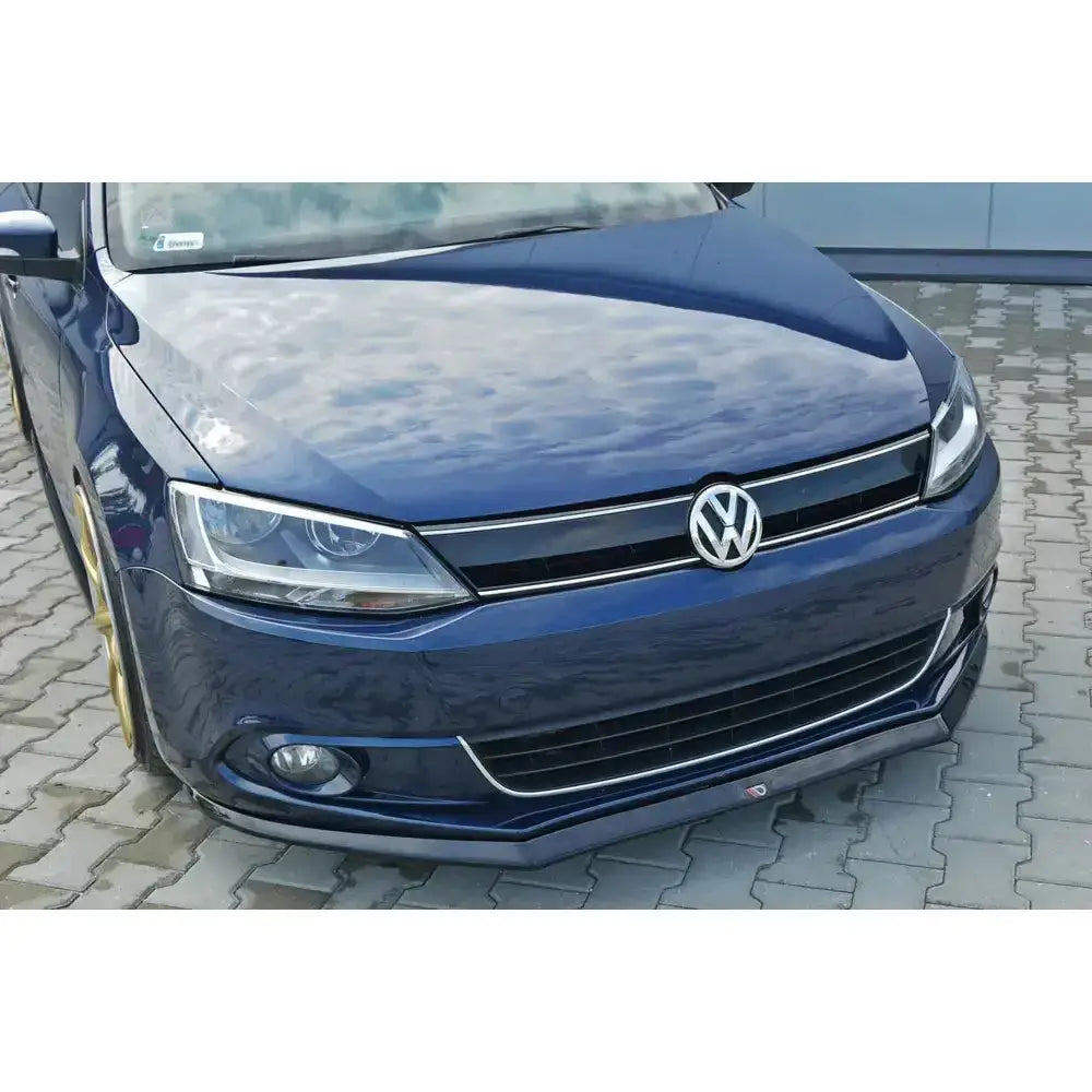 Frontsplitter på blå Volkswagen Jetta Mk6 Sedan Preface med svart spoiler og kromdetaljer sett forfra.