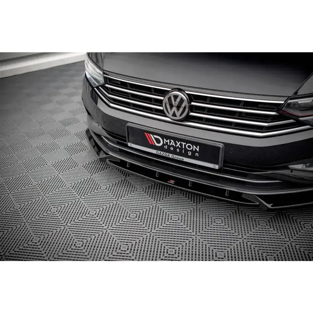 Frontsplitter på svart Volkswagen Passat B8 Facelift med Maxton Design-logo og krom grill.