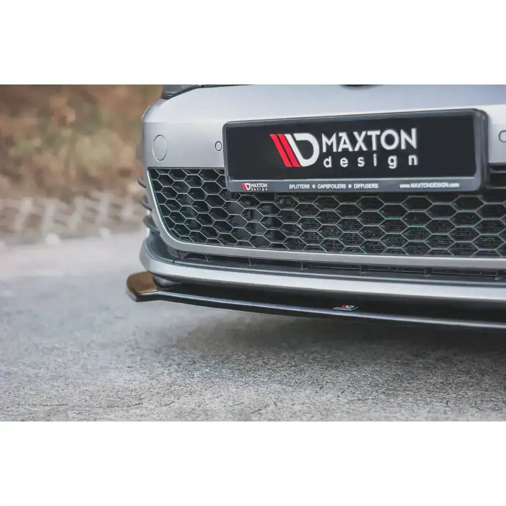Front lip V.2 frontspoiler til VW Golf VII GTI i svart plast, sett skrått nedenfra under støtfanger.