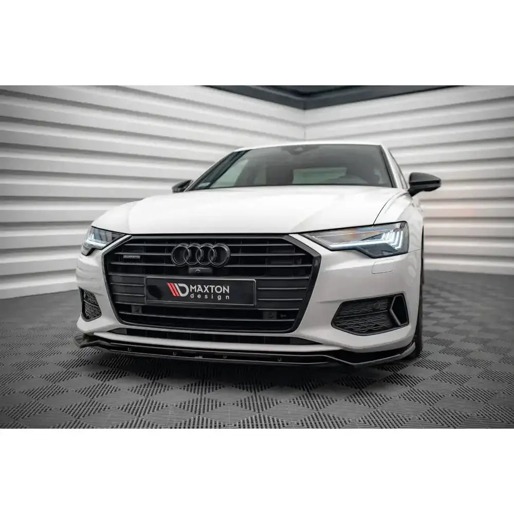 Frontspoiler på Audi A6 C8 V.3 med sort grill, LED-lys og Maxton Design-logo foran på hvit bil.