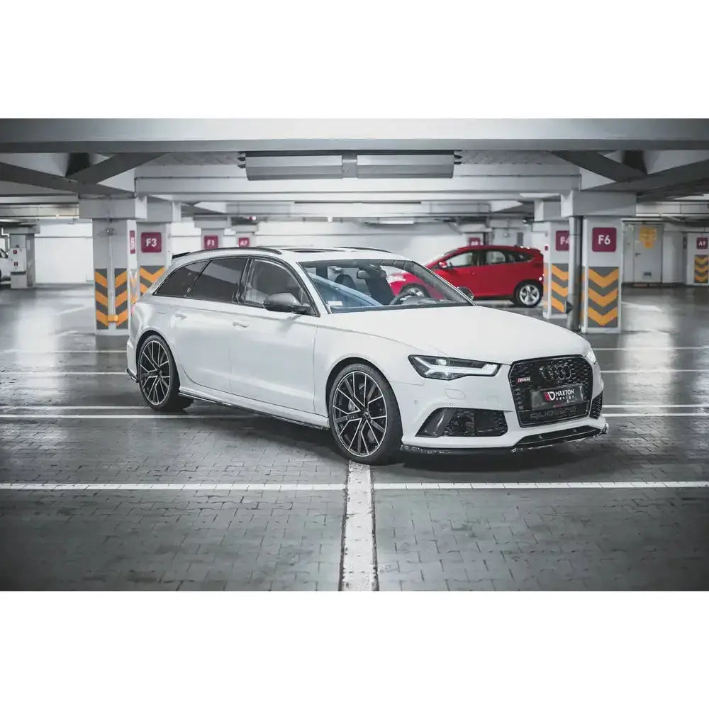 Frontspoiler på hvit Audi RS6 C7 med sorte felger, sotede ruter og sportslig front i parkeringshus.