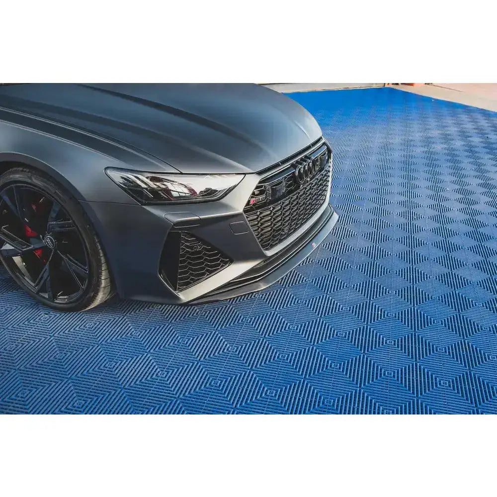 Front splitter på Audi RS6 C8 V.3 sett forfra i halvprofil, parkert på blå gulvmatte med mønster.
