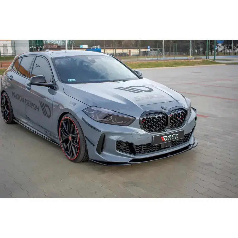 Frontspoiler på BMW 1 F40 M-Pack med sorte felger, røde detaljer og sportslig frontdesign.