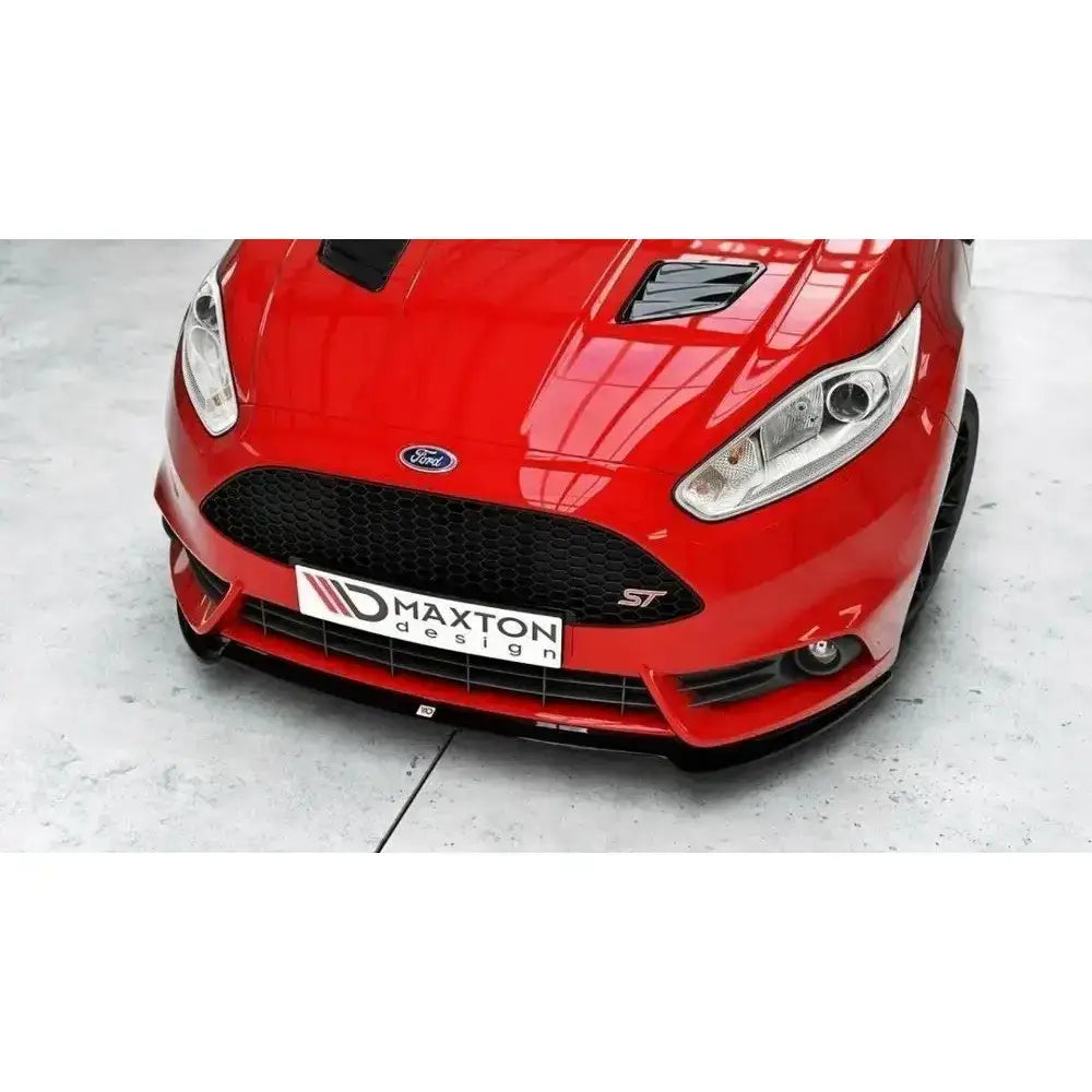 Frontsplitter på rød Ford Fiesta Mk7 ST Facelift med svart grill og spoiler sett skrått ovenfra.