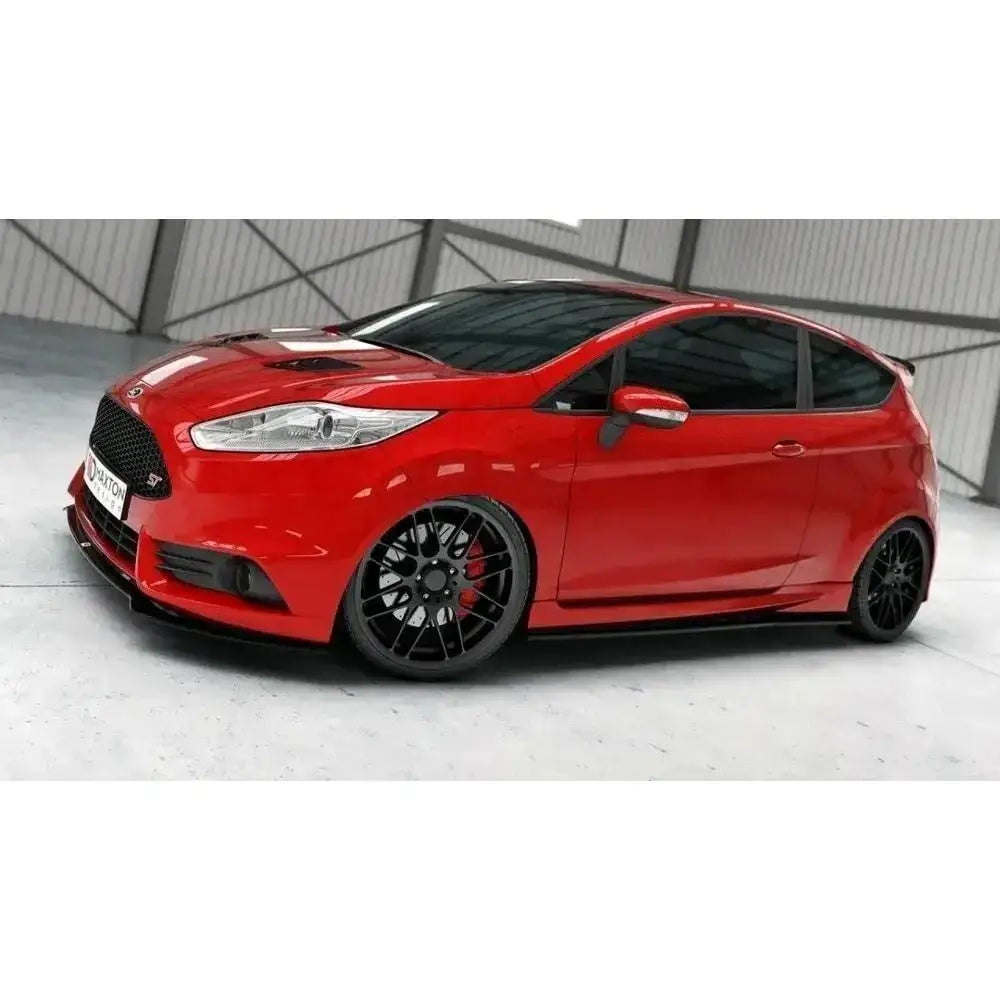 Front splitter på rød Ford Fiesta Mk7 ST Facelift med sorte detaljer og aluminiumsfelger innendørs.