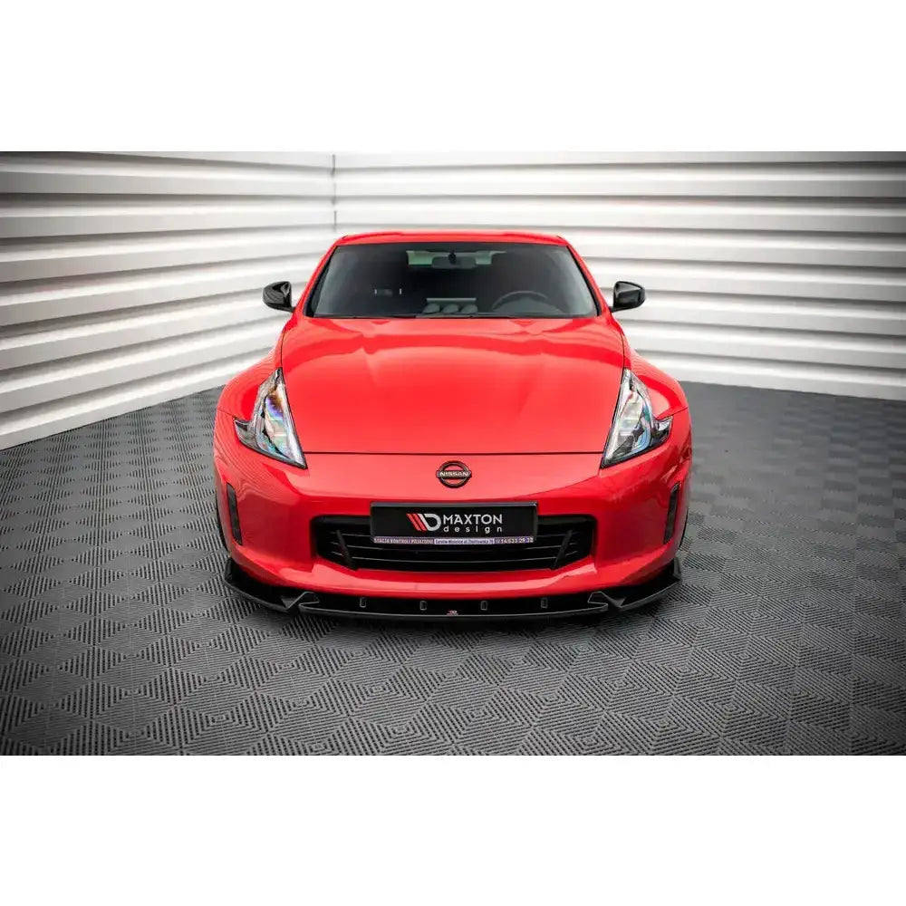 Frontsplitter på rød Nissan 370Z Facelift 12-20 sett forfra med sort spoiler og markante lykter.