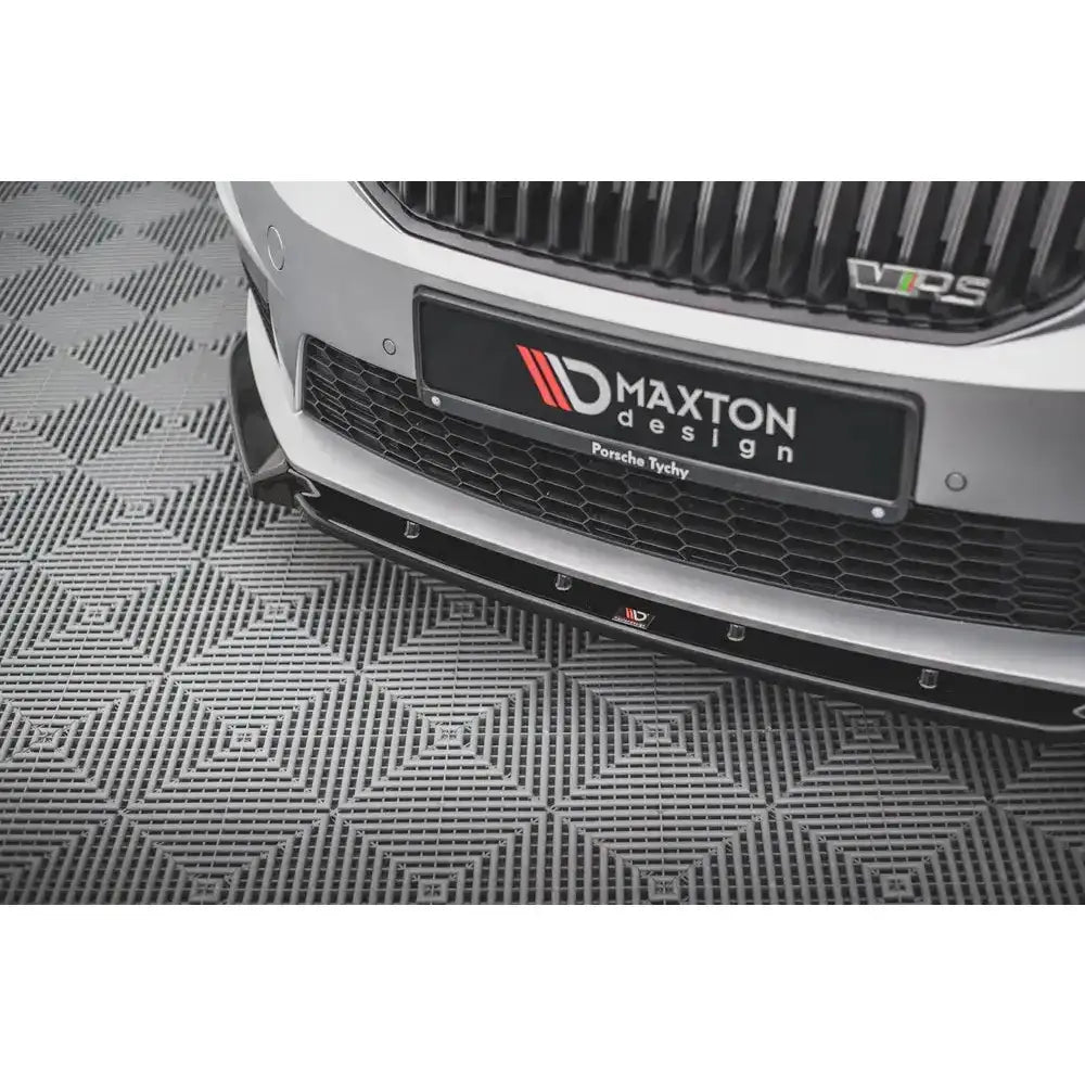 Front splitter på Skoda Octavia RS Mk3 med sort spoiler og grilldetaljer, parkert på grått gulv.