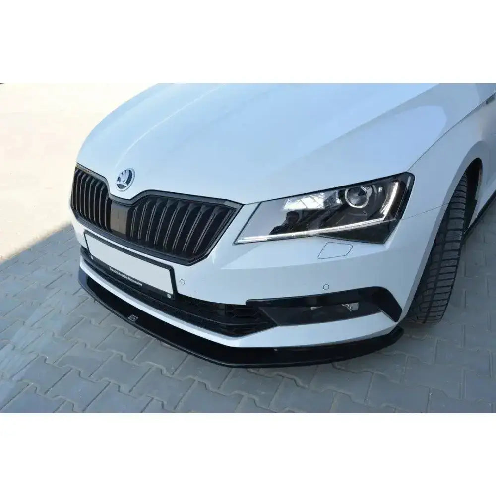 Frontsplitter til Skoda Superb III, nærbilde av hvit bil med svart spoiler og tydelige frontlys.