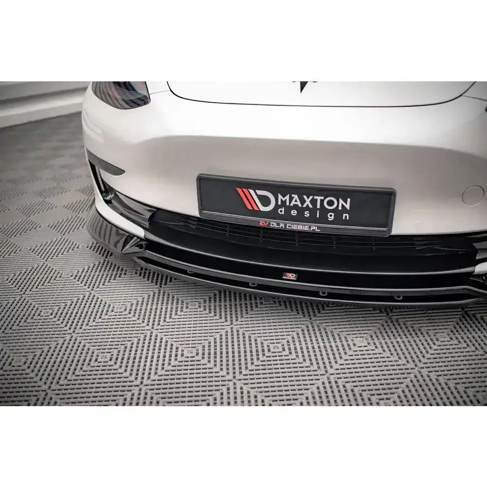 Frontsplitter til Tesla Model 3 i sort blank finish med Maxton Design-logo, montert på hvit bil.