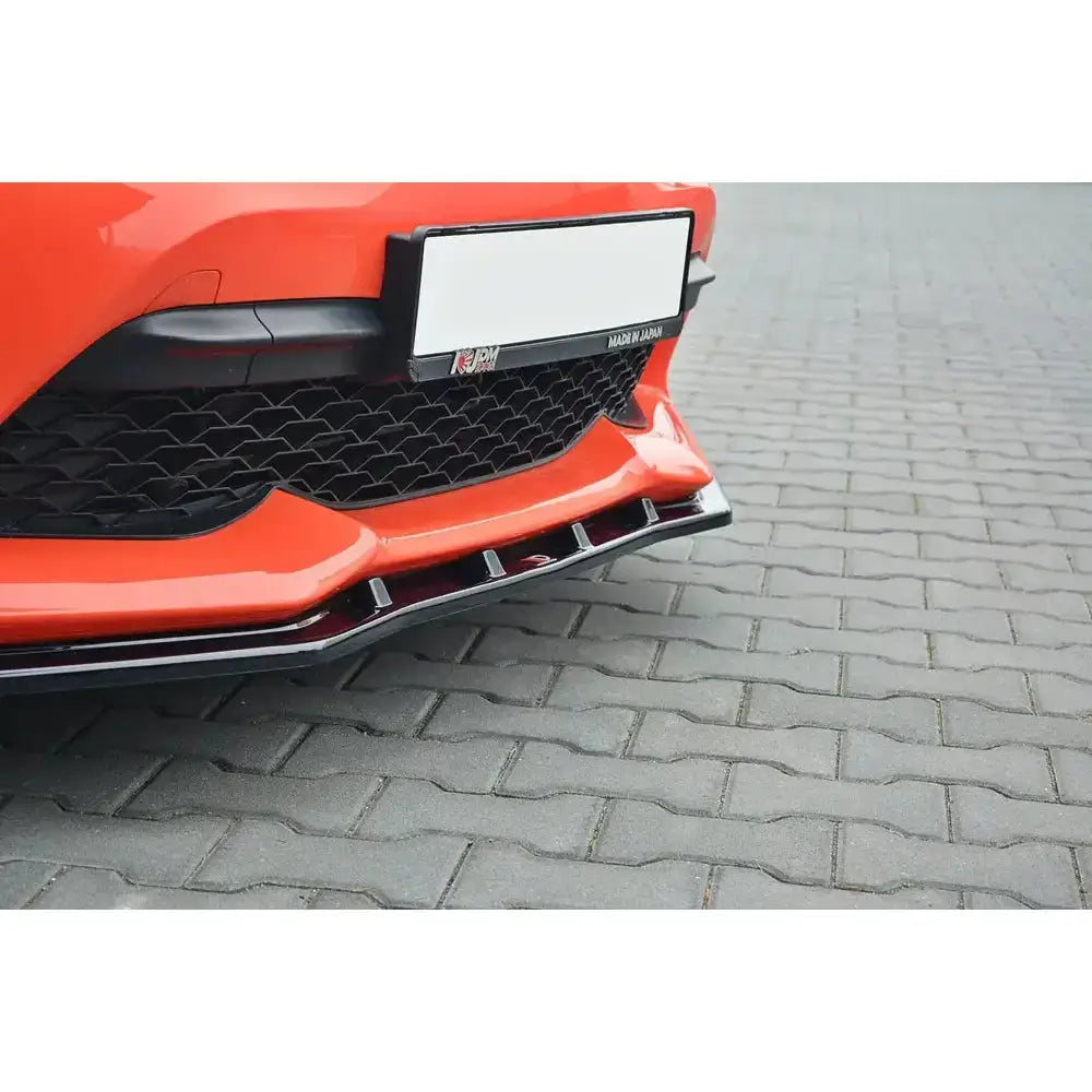 Frontsplitter på Toyota GT86 Facelift V.3 i oransje, montert på bil med svart grill, parkert på brostein.