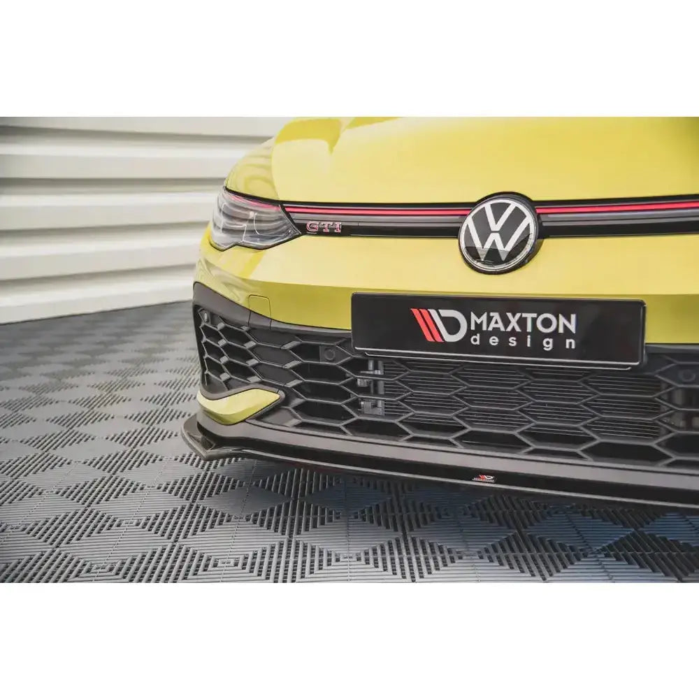 Front lip på Volkswagen Golf 8 GTI Clubsport med sort splitter og røde detaljer på gul bil.