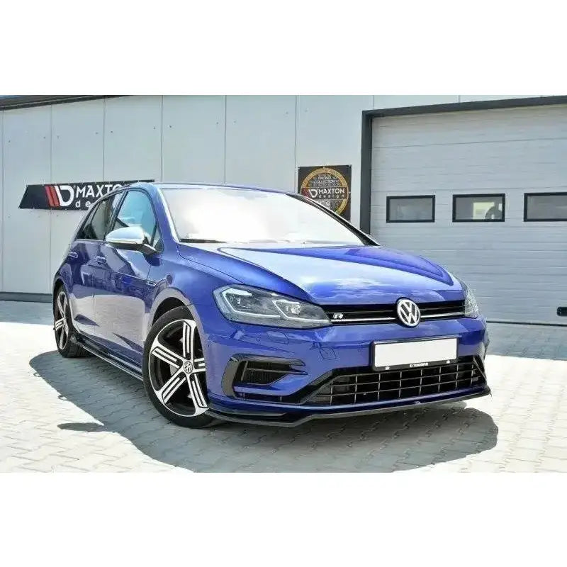 Frontspoiler på blå VW Golf VII R Facelift med svarte felger og sporty frontfanger utenfor industribygg.