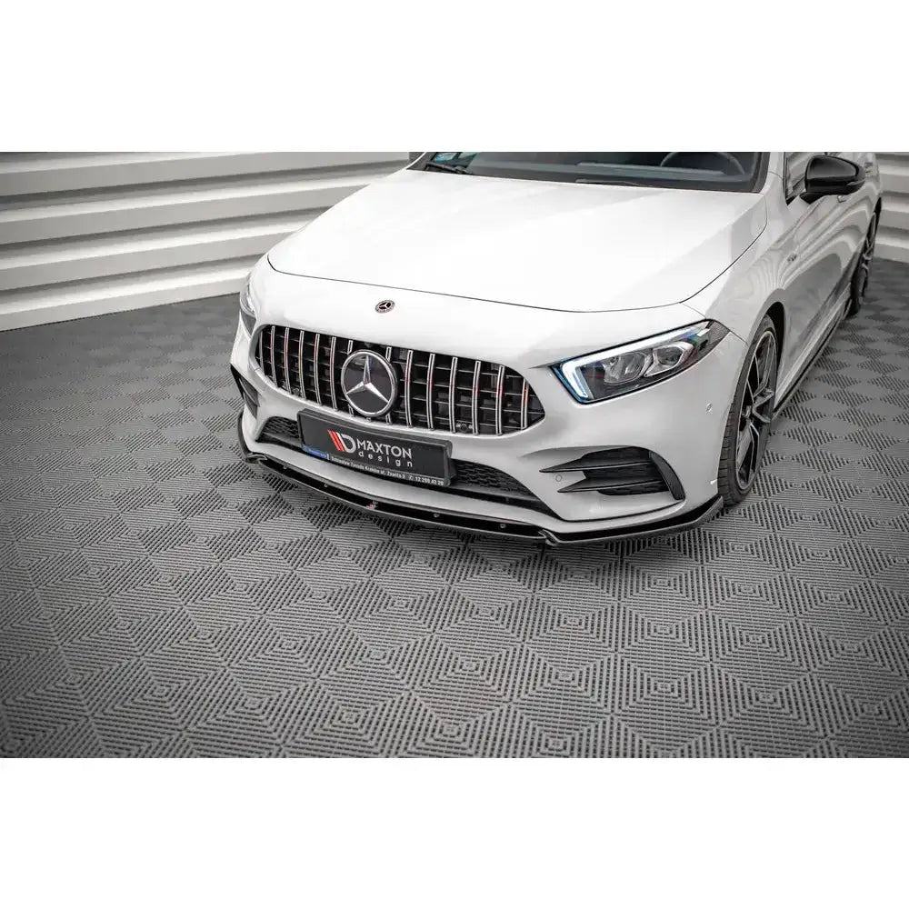 Front lip på Mercedes A35 AMG med sort frontsplitter og markant grill, sett skrått forfra på grått gulv.