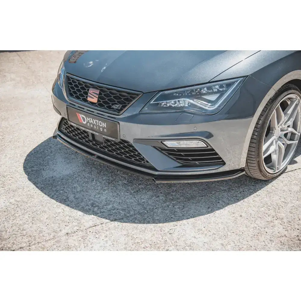 Front splitter for Seat Leon Cupra V.4 i blank sort plast montert under støtfanger, synlig Maxton-logo.