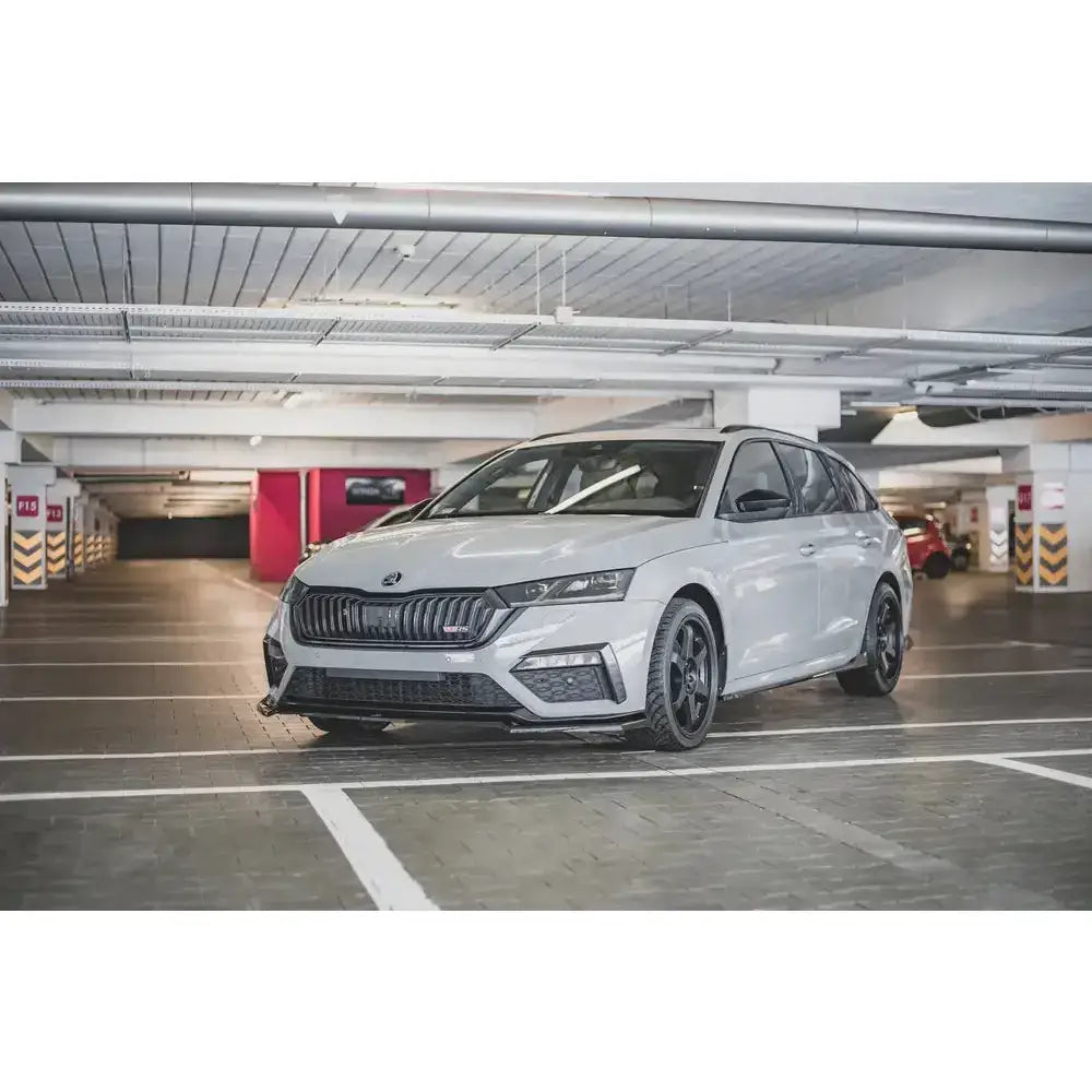 Frontspoiler på Skoda Octavia RS Mk4 med svarte felger, sett skrått forfra i parkeringshus.