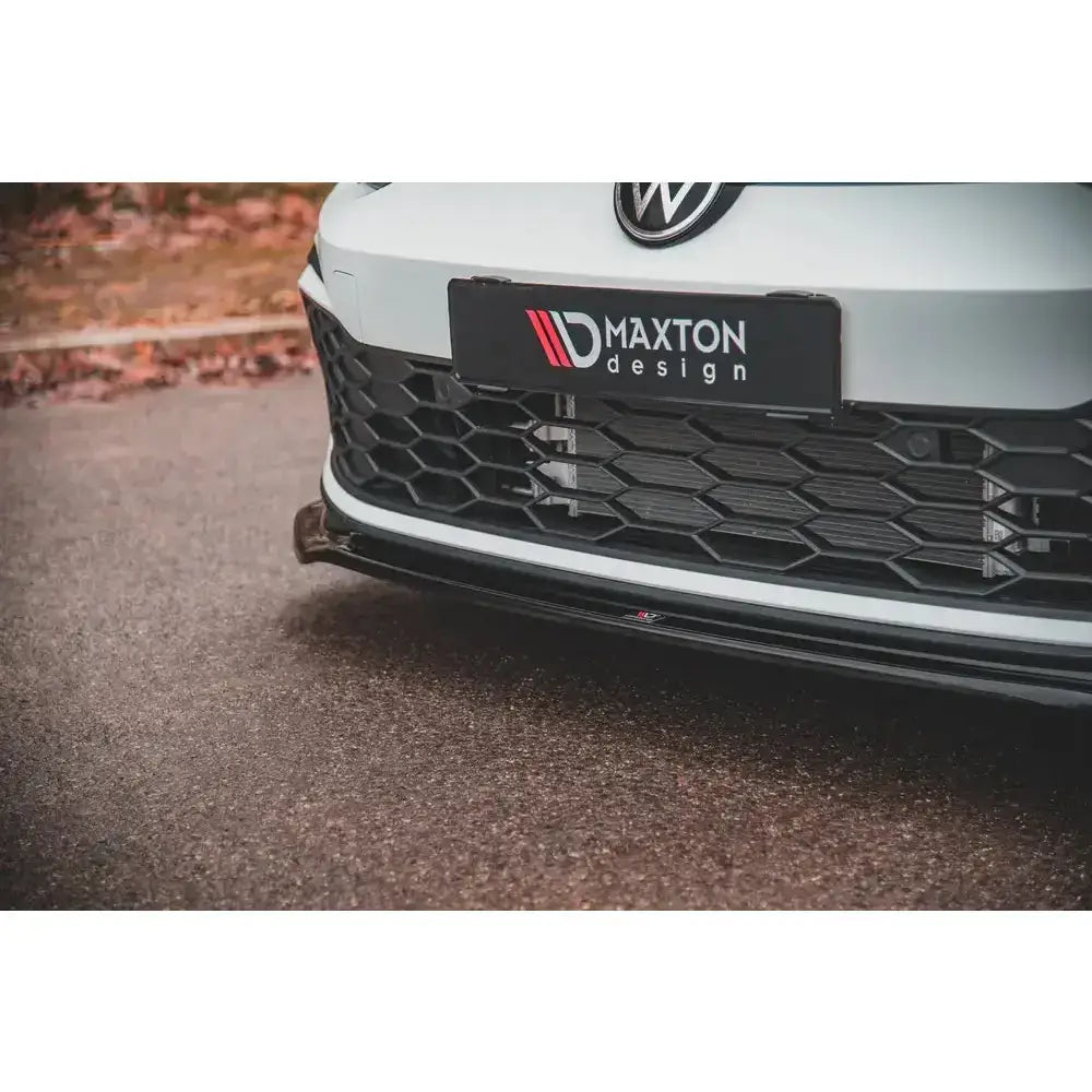 Front splitter på Volkswagen Golf 8 GTI med blank sort plast og bikubemønstret grill.