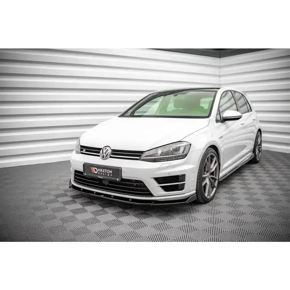 Frontsplitter på Volkswagen Golf R Mk7 med sorte detaljer, sett forfra og fra venstre i lyst rom.