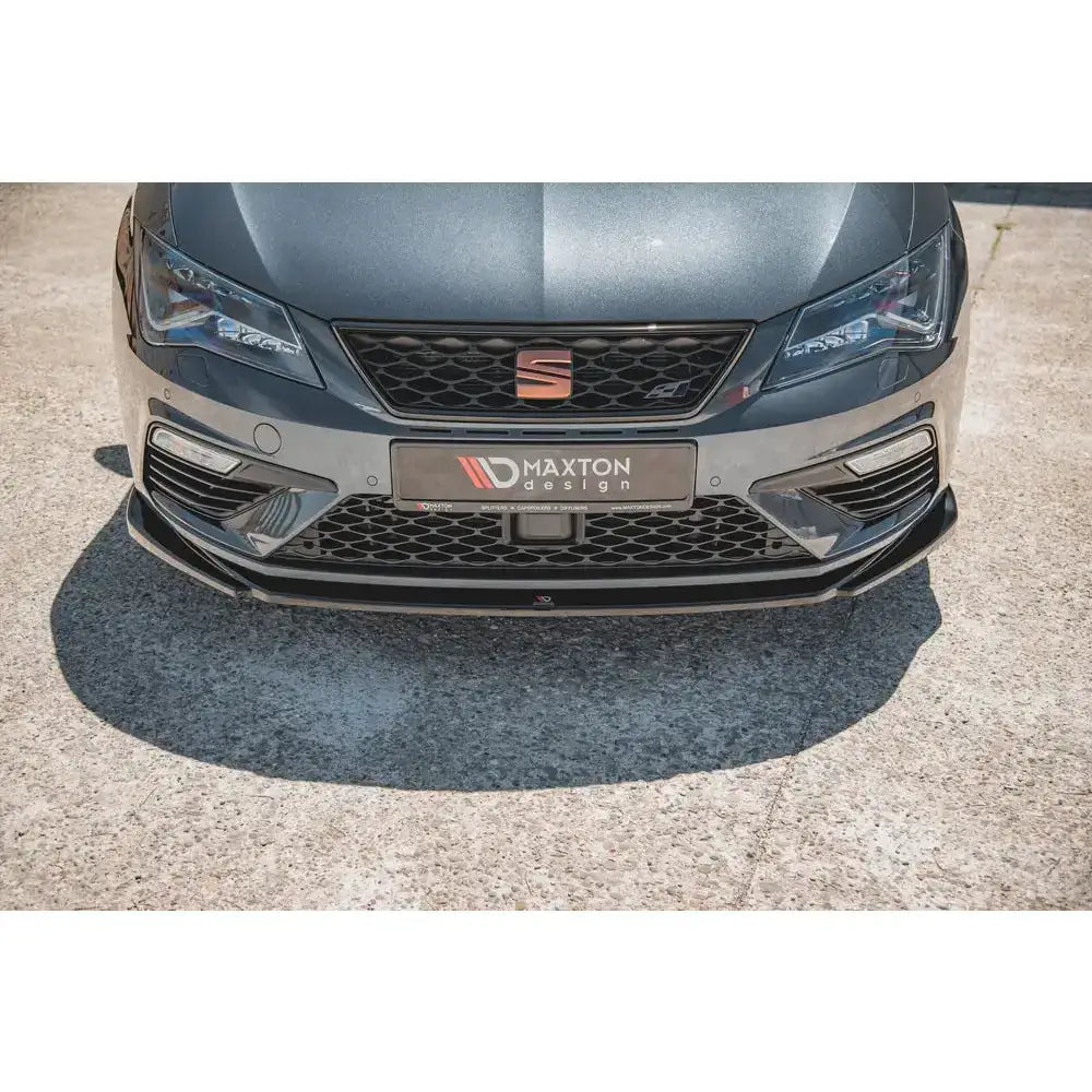 Frontsplitter til Seat Leon Cupra FR Mk3 FL, sort og blank, montert på grå bil, nærbilde forfra.