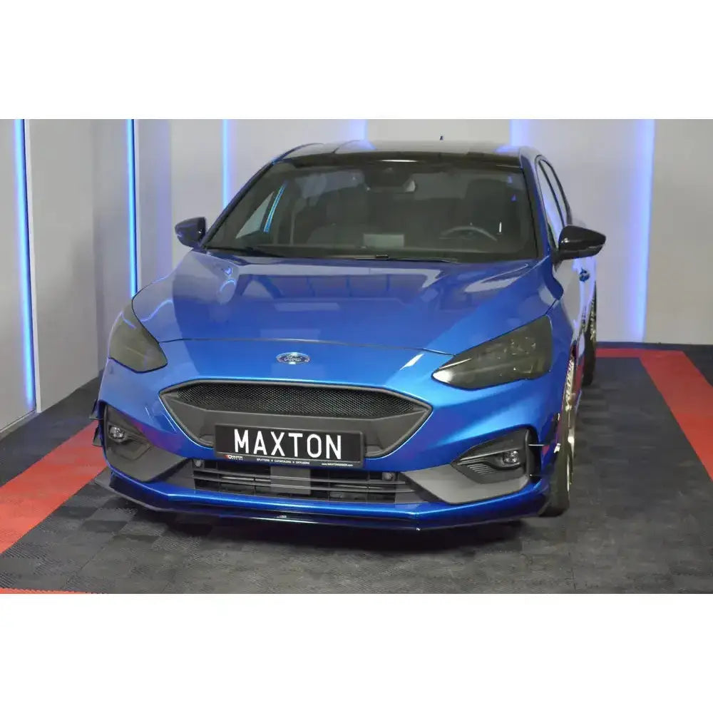 Frontspoiler på blå Ford Focus ST MK4 med svart grill og Maxton-skilt, sett rett forfra.