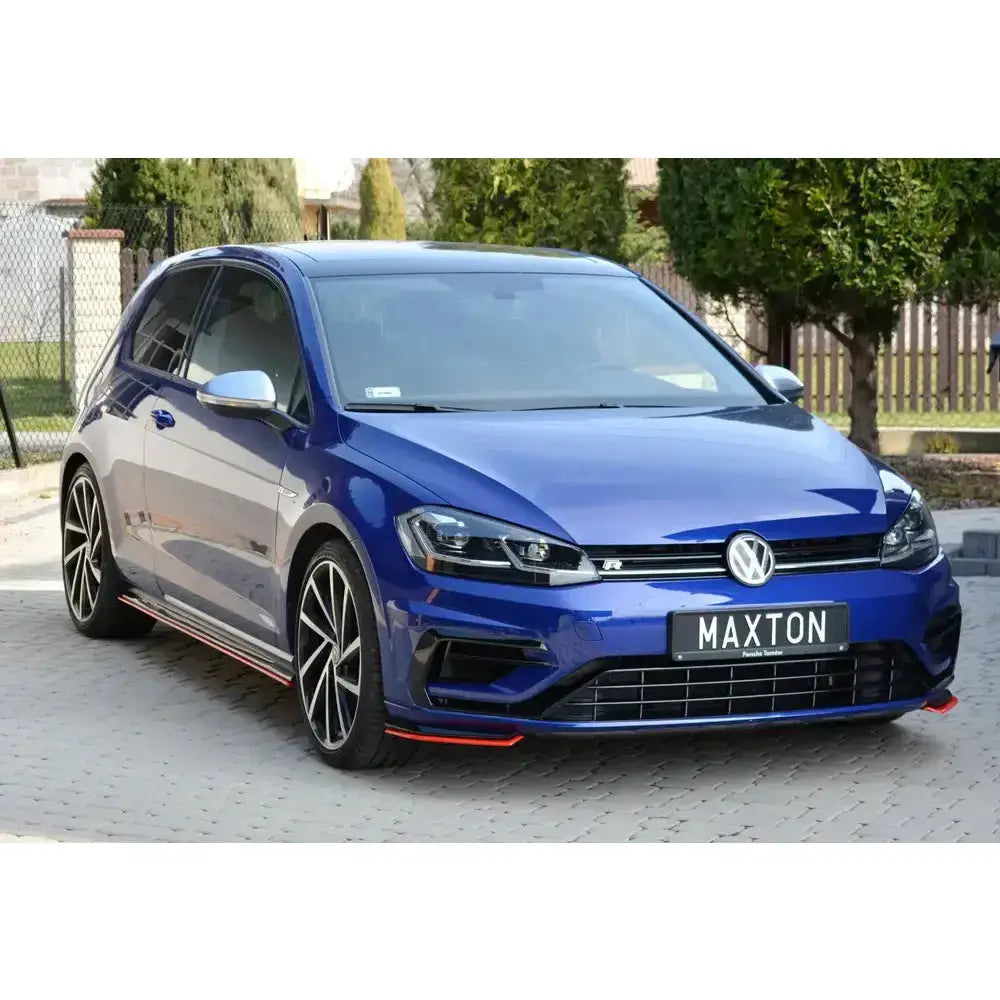 Frontspoiler på blå VW Golf 7 R Facelift med svarte felger og oransje detaljer langs skjørtene.