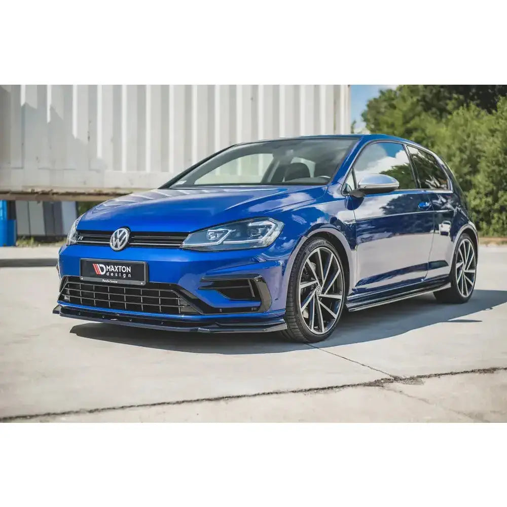 Frontspoiler på blå VW Golf 7 R Facelift med sorte detaljer og aluminiumsfelger utendørs.