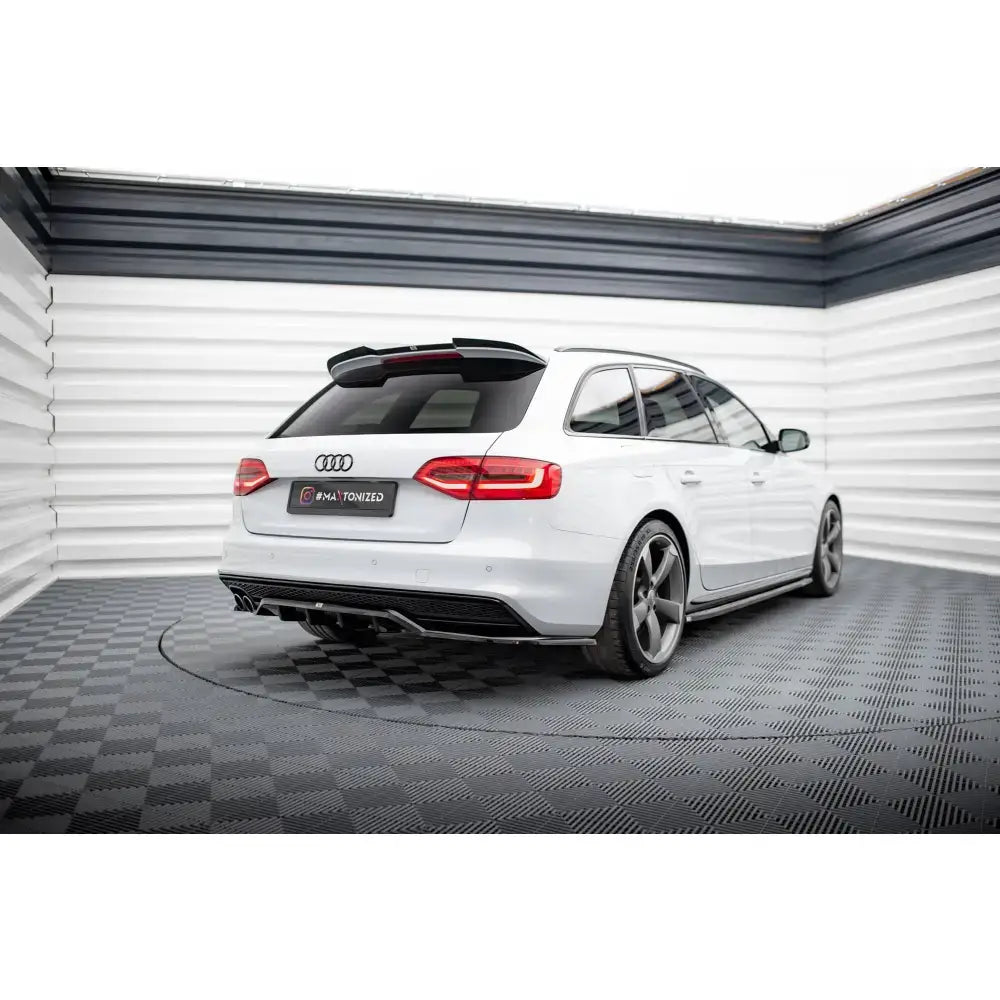 Frontspoiler på hvit Audi RS4 B9 Facelift stasjonsvogn med sotede ruter og sorte felger, sett skrått bakfra.